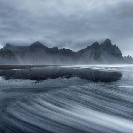 Vestrahorn et la plage de Stokksnes sont deux merveilles naturelles situées dans le sud-est de l'Islande, près de la petite ville de Höfn. Ils offrent des paysages époustouflants et sont des destinations très prisées des voyageurs et des photographes. Vestrahorn est une montagne emblématique qui se dresse majestueusement près de la côte. Elle est composée de pics pointus et de falaises abruptes, formant un paysage dramatique et impressionnant. La montagne est entourée par les eaux de l'océan Atlantique et le magnifique lac de lave de Vestrahorn. Les contrastes entre les sommets enneigés, les plages de sable noir et les eaux agitées créent une atmosphère mystique et captivante. La plage de Stokksnes est située au pied de Vestrahorn et est considérée comme l'une des plages les plus photographiées d'Islande. Elle est célèbre pour son sable noir, ses dunes de sable et ses formations rocheuses spectaculaires. Lorsque le temps est calme, le reflet des montagnes dans les mares d'eau créées par la marée basse crée des images saisissantes. La région de Vestrahorn et Stokksnes offre de nombreuses possibilités de randonnées et d'exploration. Les passionnés de photographie peuvent capturer des vues incroyables à chaque pas, en jouant avec les contrastes, la lumière et les paysages spectaculaires. Il convient de noter que Vestrahorn et la plage de Stokksnes se trouvent sur des terres privées, et pour y accéder, il est généralement nécessaire de payer des frais d'entrée à l'opérateur local. Cela contribue à la préservation et à la conservation de ces magnifiques sites naturels.